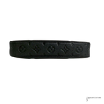 Black leather belt with embossed pattern on a white background