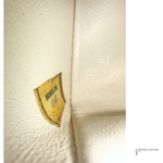 Close-up of a leather product with a visible brand label on a light background