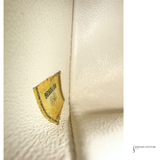 Close-up of a leather product with a visible brand label on a light background