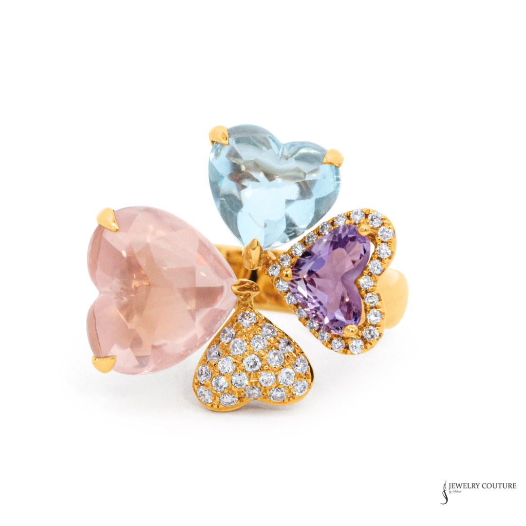 Three heart-shaped gemstones in pink, blue, and purple with gold accents on a white background.