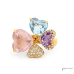 Three heart-shaped gemstones in pink, blue, and purple with gold accents on a white background.
