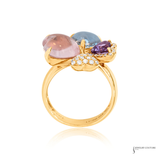 Gold ring with multicolored gemstones on a white background