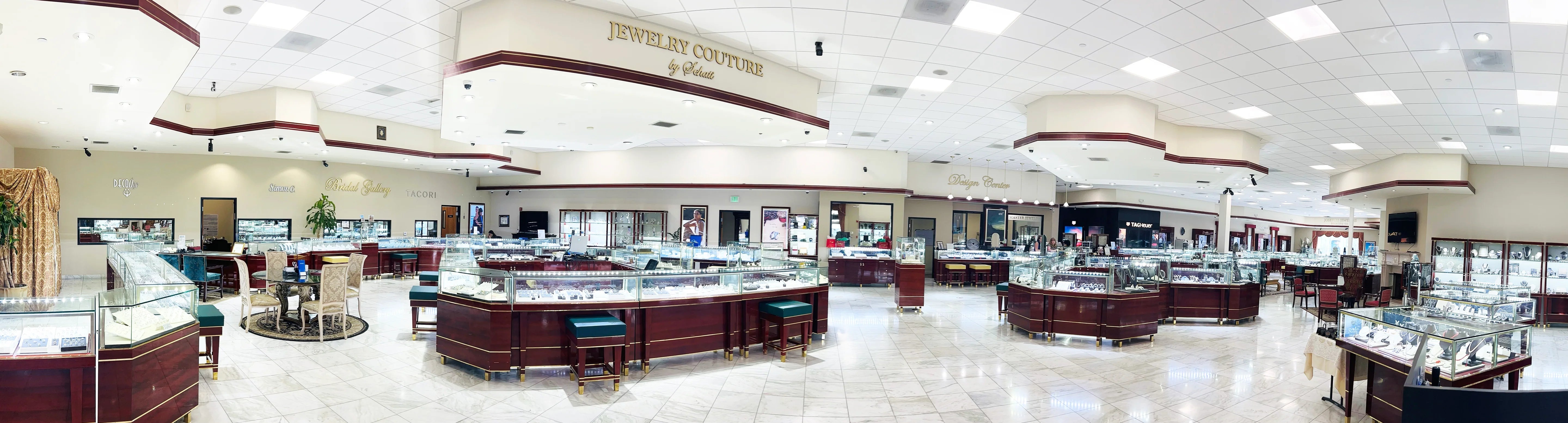 Panoramic view of a jewelry store with display cases and a large sign on the wall.