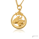 24K gold Year of the Rabbit pendant with rabbit on a crescent moon beneath three stars, close-up view