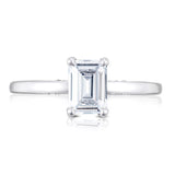 Diamond ring with emerald-cut gemstone on a white background
