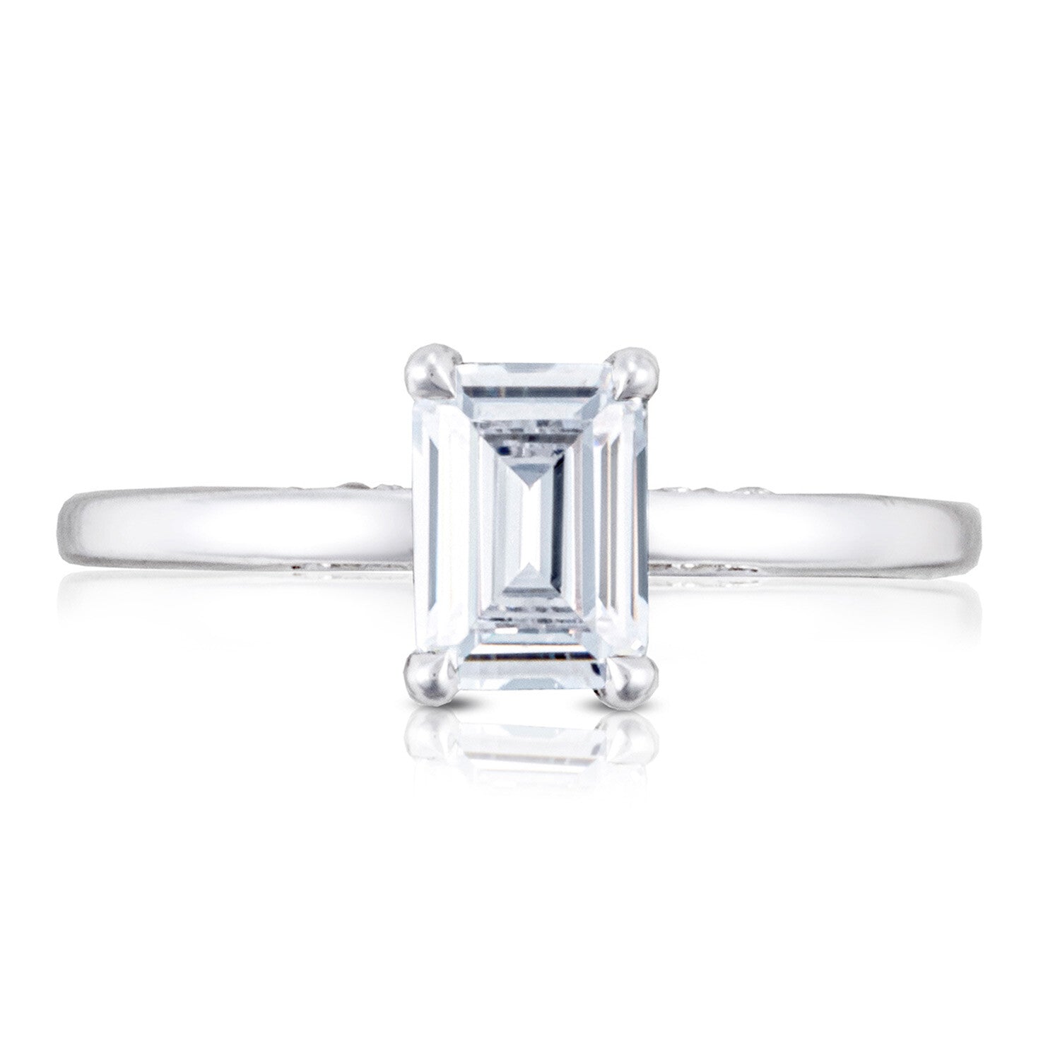 Diamond ring with emerald-cut gemstone on a white background