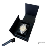 A silver-tone stainless steel watch with a cream-colored dial and crystal-embellished bezel, presented inside an open black jewelry box. A black branded ribbon with 'DAVID YURMAN' is visible in the lower-left corner, and a 'JEWELRY COUTURE' watermark is in the lower-right corner.