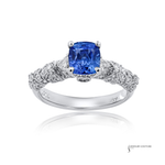 Ring with a blue gemstone and diamond accents on a white background