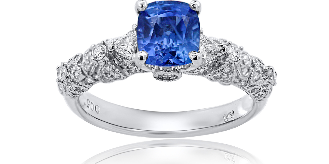 Ring with a blue gemstone and diamond accents on a white background