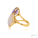 Gold ring with purple and pink gemstones on a white background