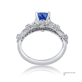 Elegant ring with a blue gemstone and diamond accents on a white background