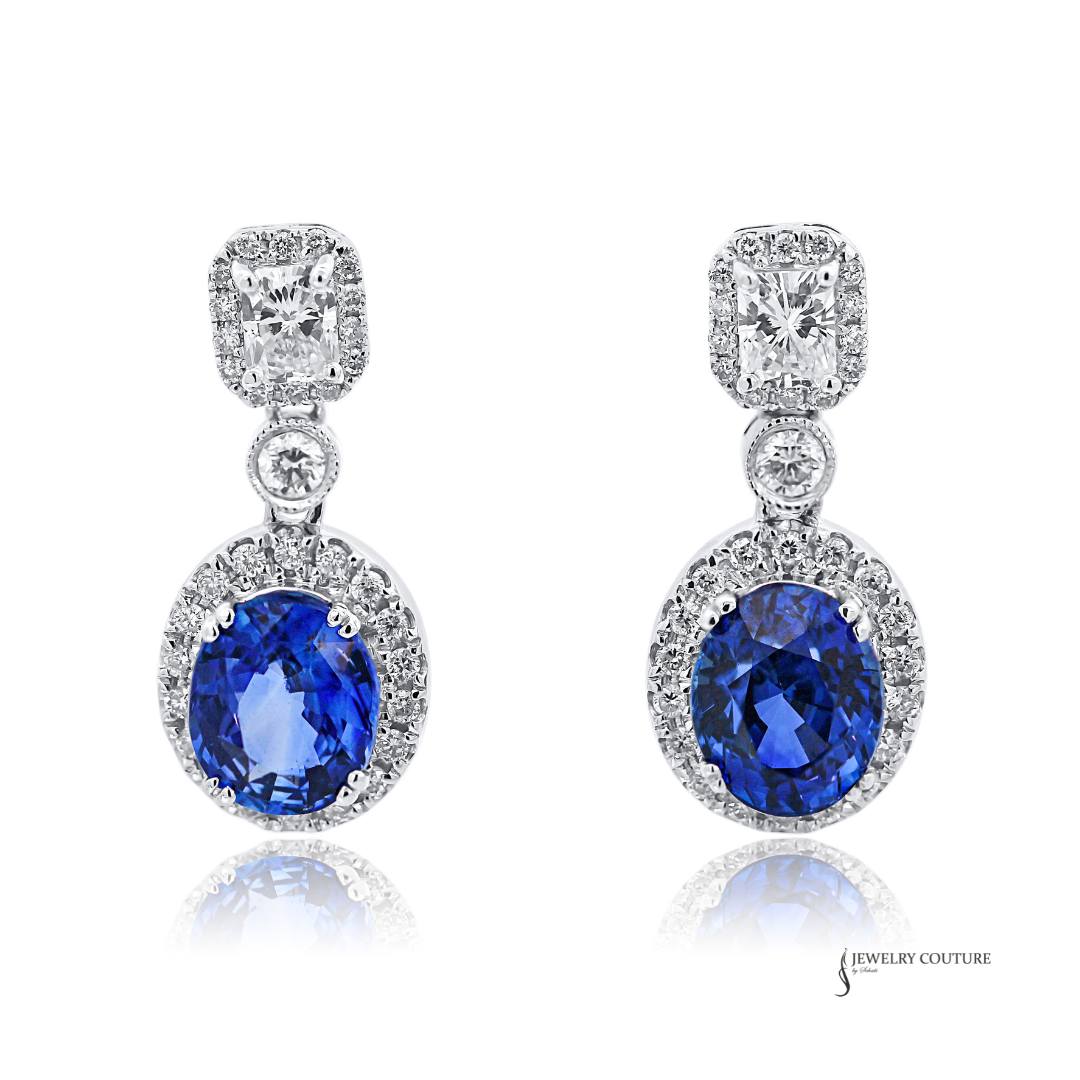 Pair of earrings with blue gemstones and diamond-like stones on a white background