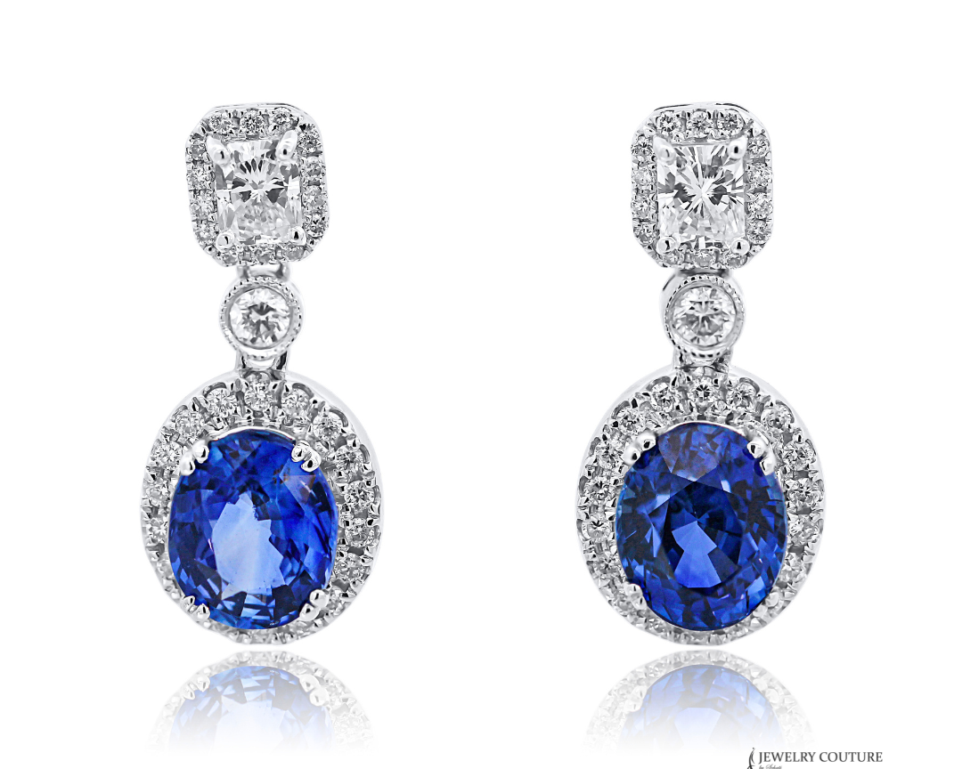Pair of earrings with blue gemstones and diamond-like stones on a white background