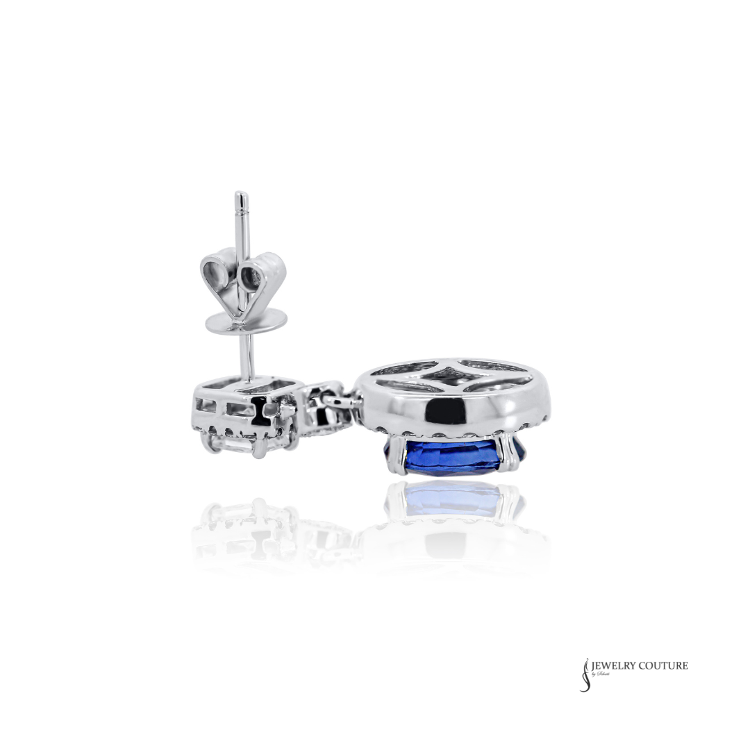 Silver earring with a blue gemstone on a white background