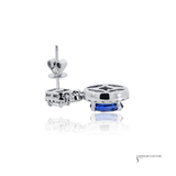 Silver earring with a blue gemstone on a white background