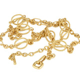 A gold chain necklace with mixed link styles, including twisted rope links and oval links, featuring a lobster clasp and a small dangling charm, shown on a plain white background.