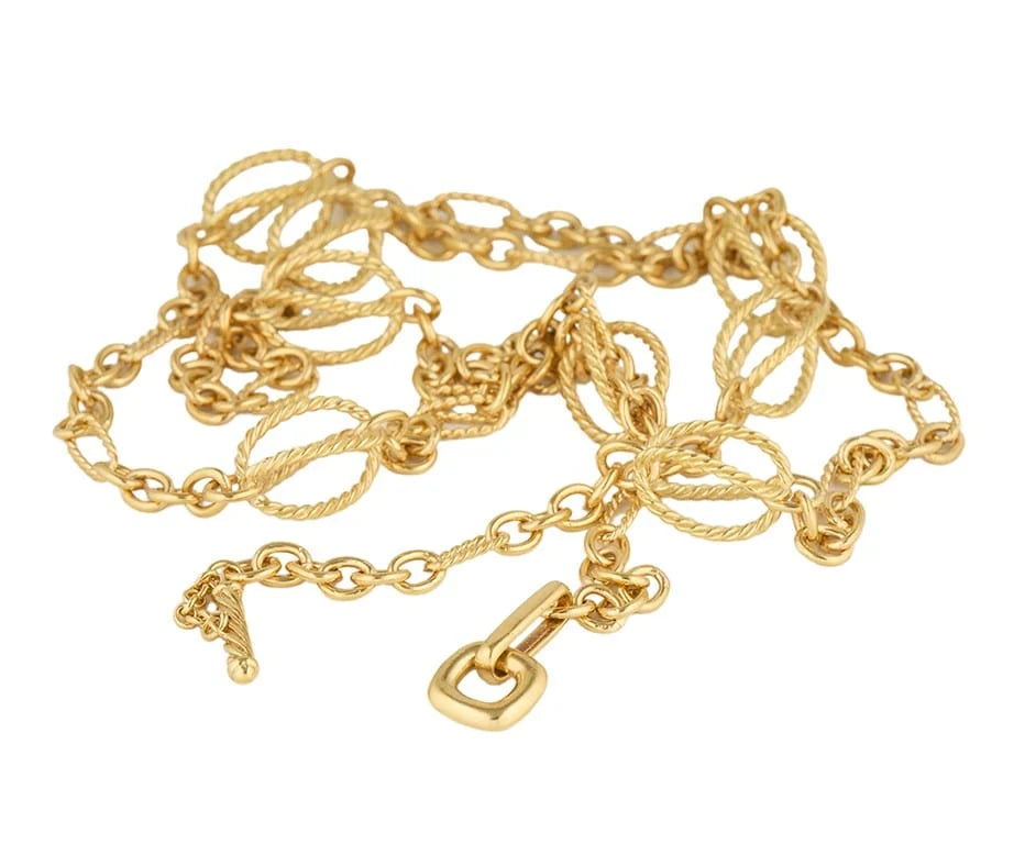 A gold chain necklace with mixed link styles, including twisted rope links and oval links, featuring a lobster clasp and a small dangling charm, shown on a plain white background.