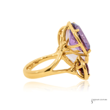 Gold ring with a purple gemstone on a white background