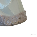 Close-up of a pearl pendant with a scalloped, textured base and a glossy iridescent white to pale blue surface, shown against a plain white background.
