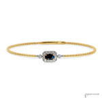 A yellow gold beaded bracelet featuring a central cluster setting with a round-cut dark blue sapphire surrounded by small diamonds, accented by round diamonds on either side, on a plain white background.