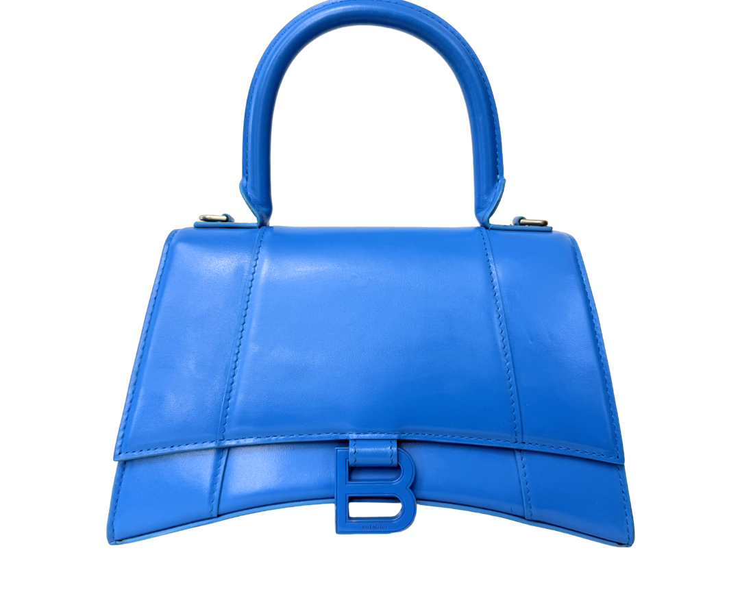 A bright blue leather handbag with a structured top handle and a matching blue B-shaped turn-lock clasp, shown against a plain white background.