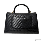 Black quilted handbag on a white background