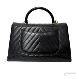 Black quilted handbag on a white background