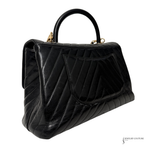Black quilted handbag on a white background