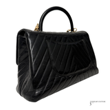 Black quilted handbag on a white background