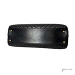 Black quilted handbag with gold studs on a white background