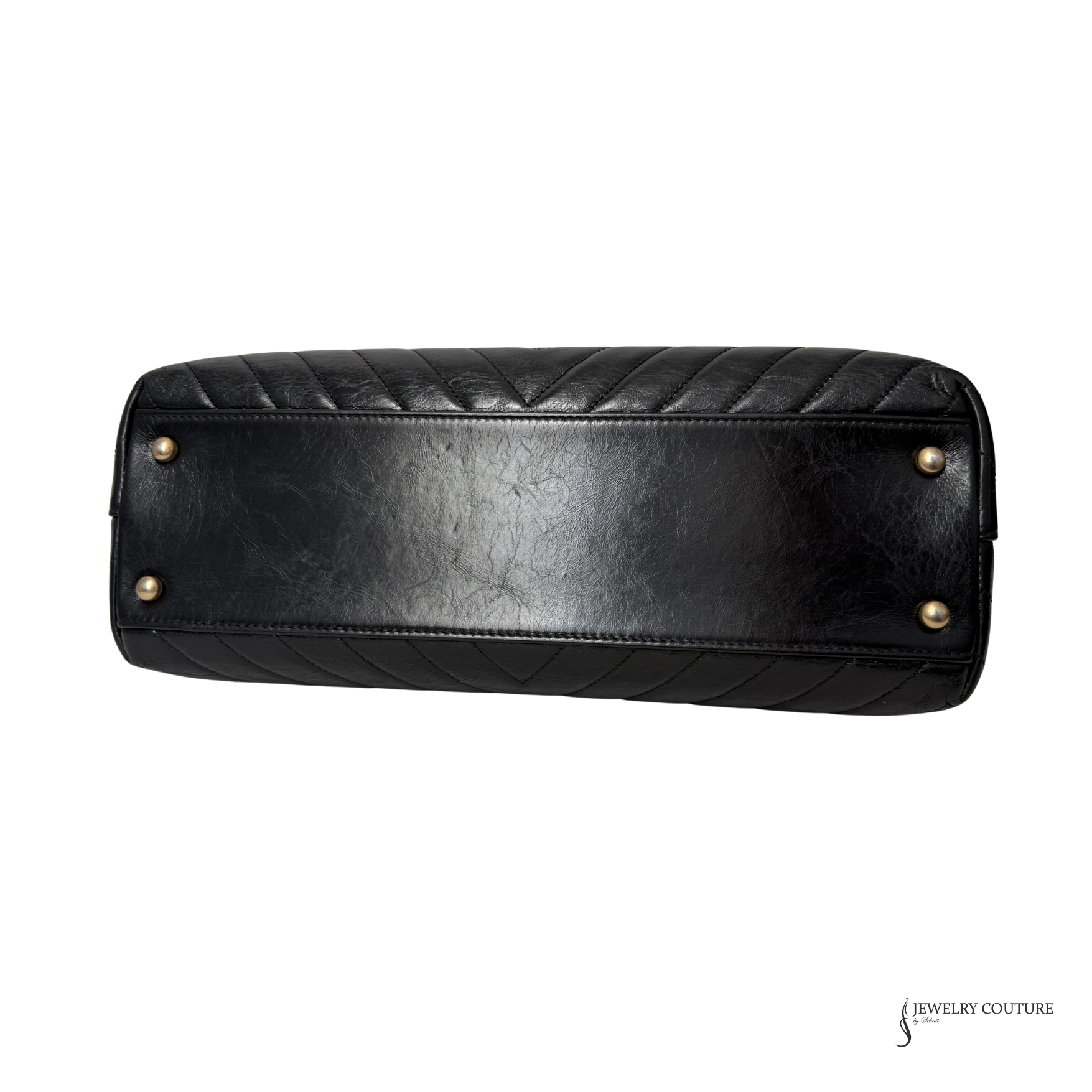 Black quilted handbag with gold studs on a white background