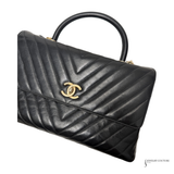 Black quilted handbag with gold logo on a white background