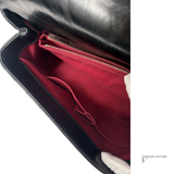 Black handbag with red interior lining, featuring a visible brand name.
