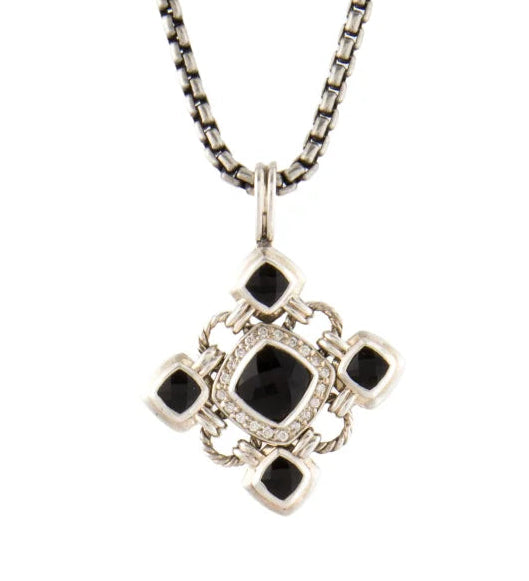 A silver-toned chain necklace with a geometric cross-shaped pendant featuring a central black square and four smaller black square accents, set against a plain white background.