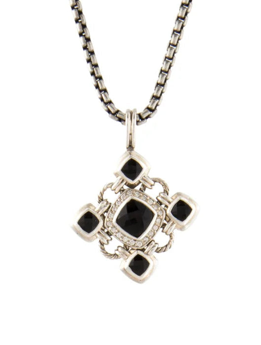 A silver-toned chain necklace with a geometric cross-shaped pendant featuring a central black square and four smaller black square accents, set against a plain white background.