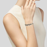 Woman wearing a silver bracelet on a plain background