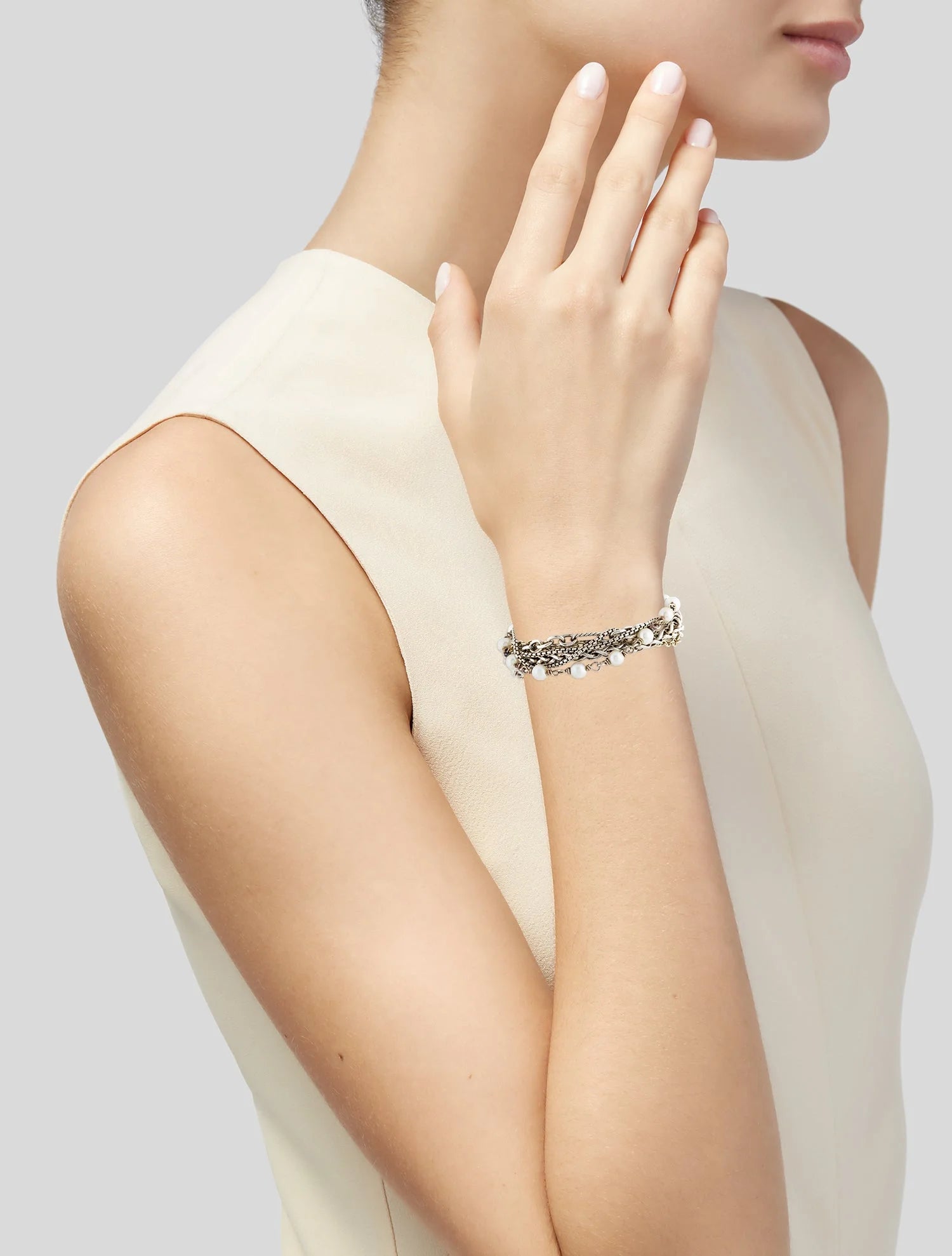 Woman wearing a silver bracelet on a plain background