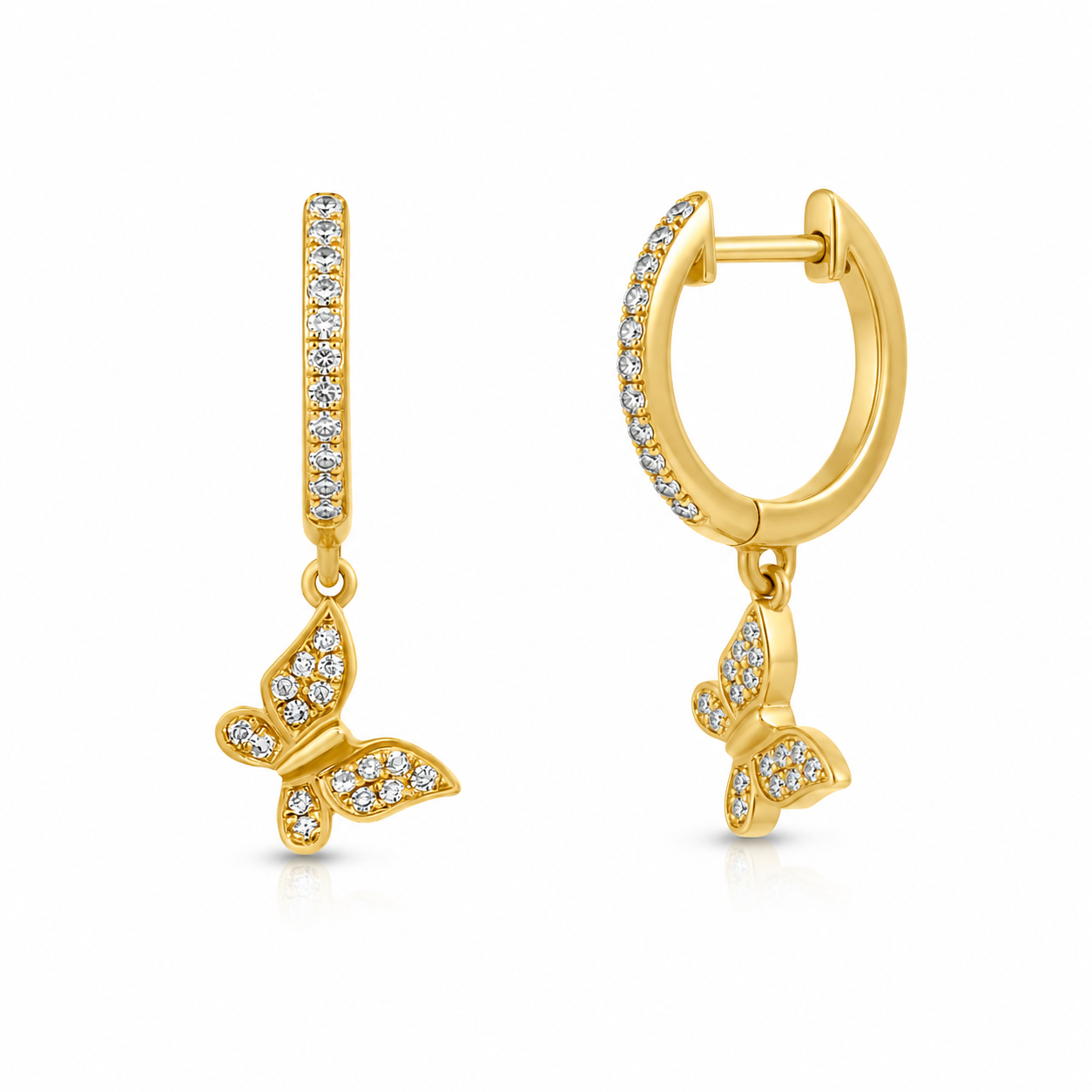 A pair of gold huggie hoop earrings with a vertical bar studded with small clear stones and a dangling butterfly charm, shown on a plain white background.