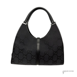 Black handbag with Gucci logo pattern on a white background