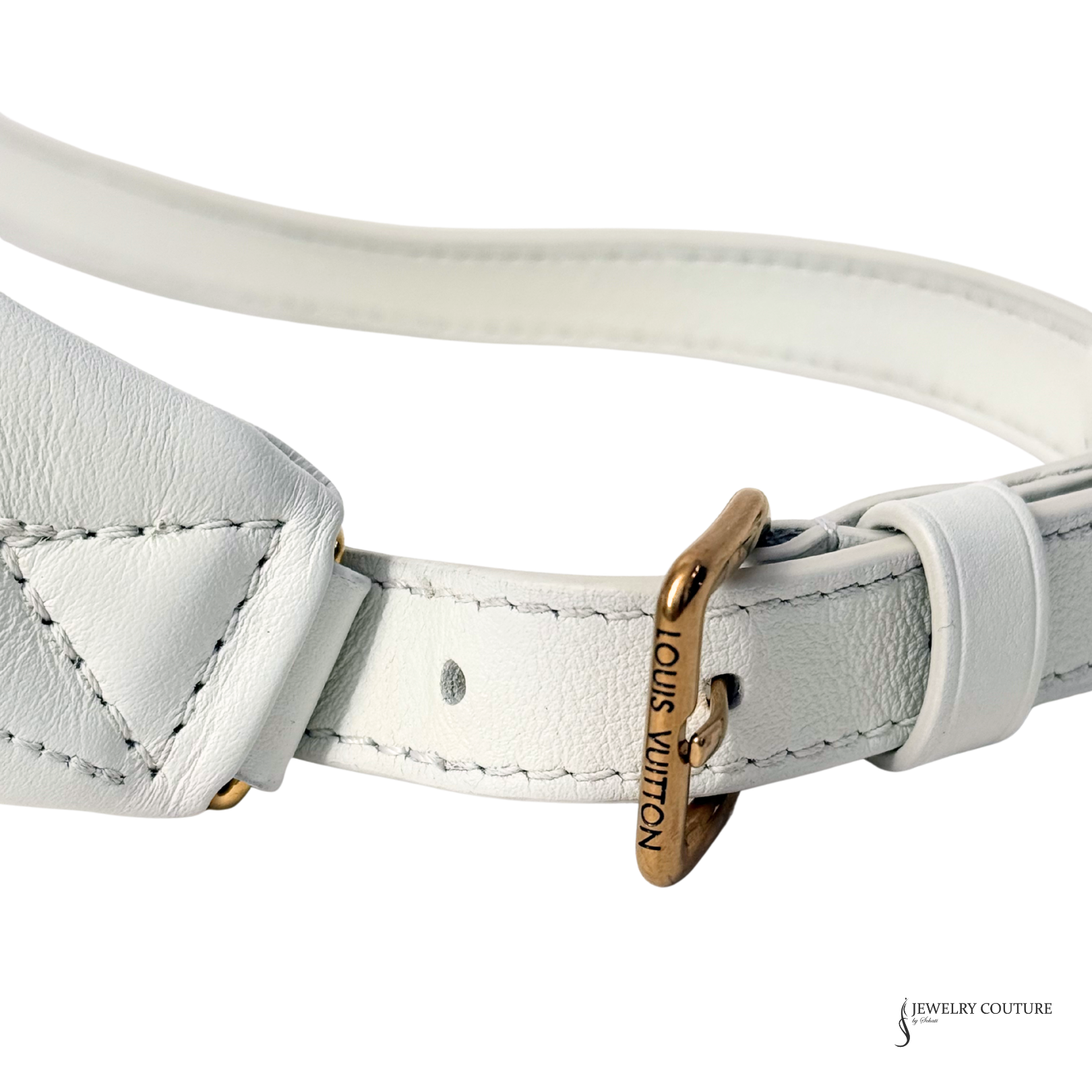 Close-up of a white leather bracelet with a gold tag on a white background