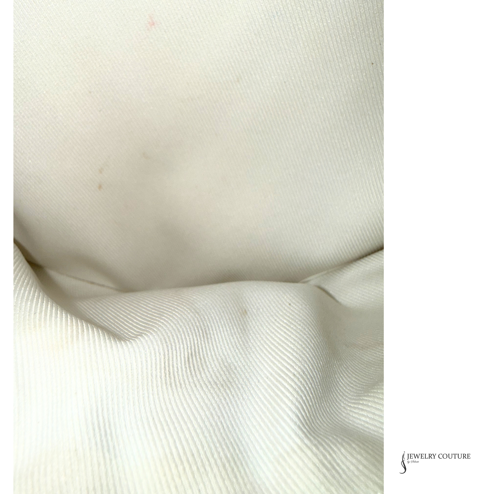 Close-up of textured white fabric with 'Jewelry Couture' branding.
