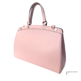 Pink handbag with gold accents on a white background