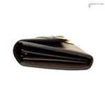Black leather wallet with gold accents on a white background