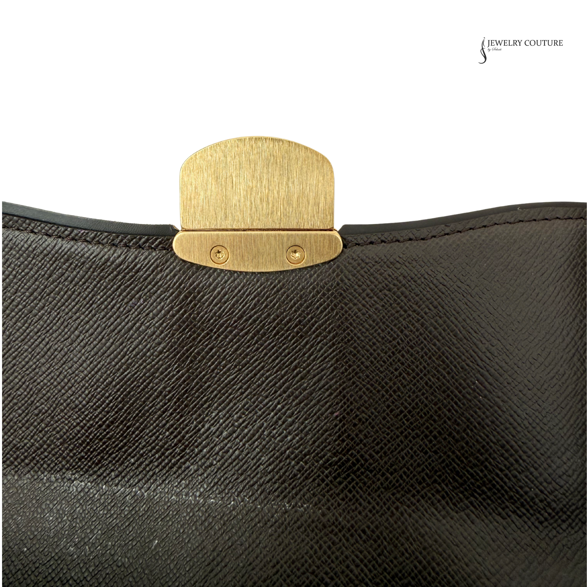 Close-up of a black textured surface with a gold clasp, featuring 'Jewelry Couture' branding.