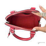 Red handbag with a hand opening it on a white background