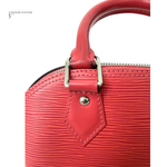 Close-up of a red handbag with a visible brand name on a white background