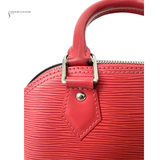 Close-up of a red handbag with a visible brand name on a white background
