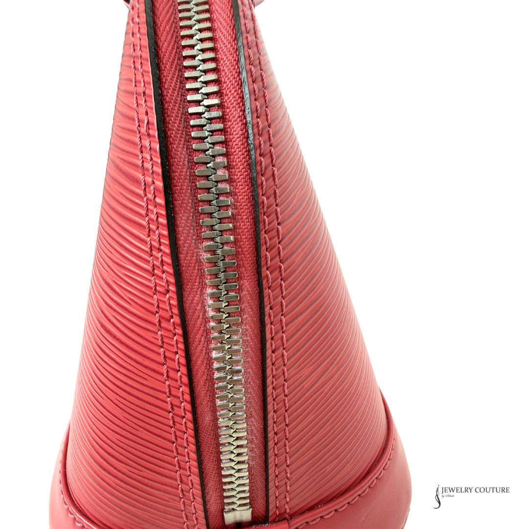 Close-up of a red handbag with a silver zipper on a white background