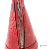 Close-up of a red handbag with a silver zipper on a white background