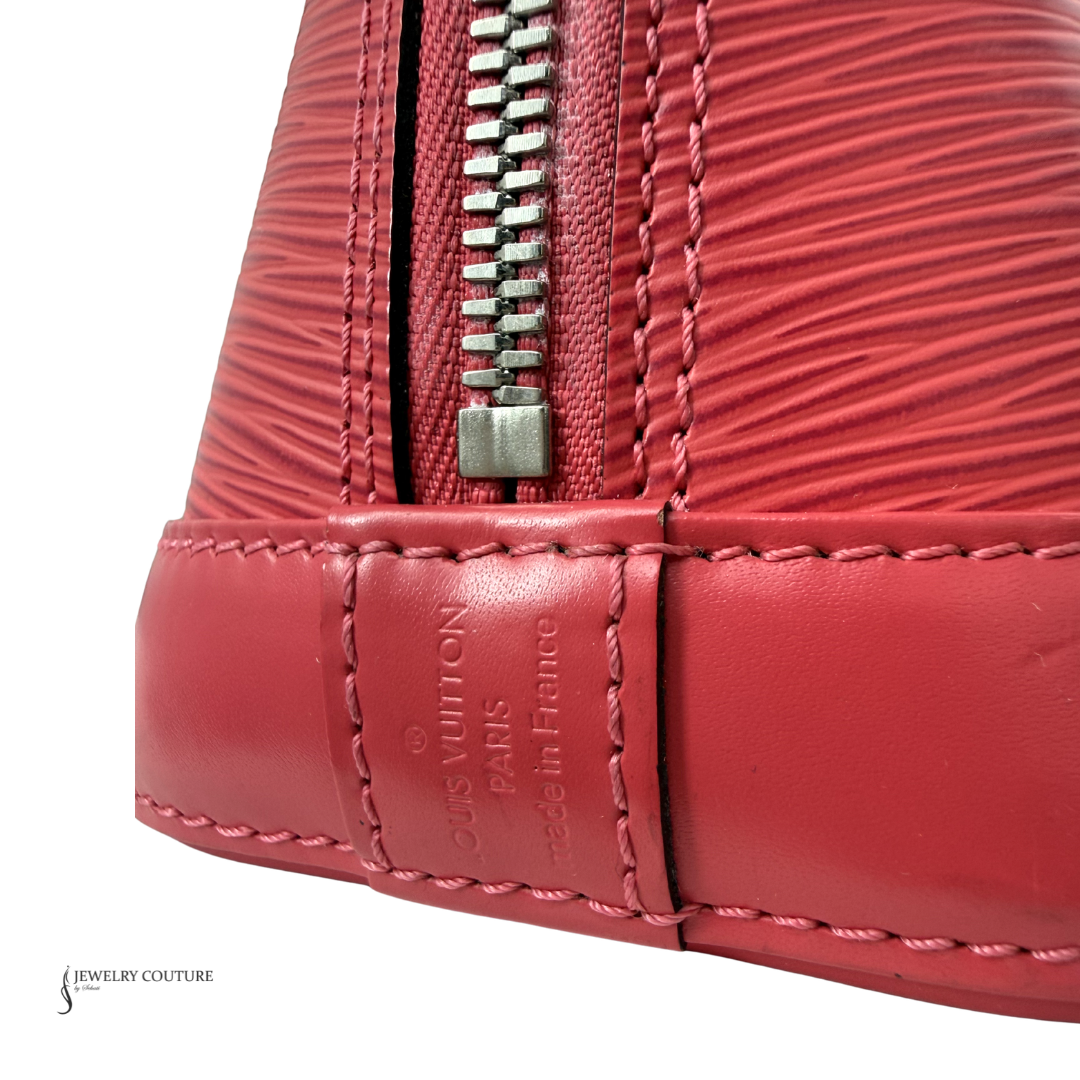 Close-up of a red Louis Vuitton handbag with a zipper on a white background